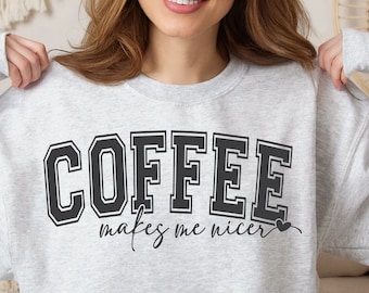 May include: A gray sweatshirt with the text "COFFEE makes me nicer" in black lettering. The text is in a college-style font.