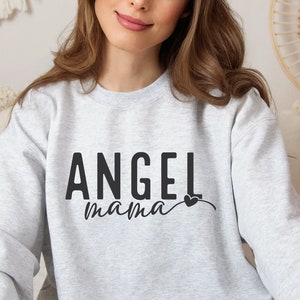 May include: A gray sweatshirt with the text "Angel Mama" in black lettering and a small black heart.