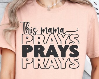 May include: A peach-colored t-shirt with the text "This mama prays prays prays" in black.