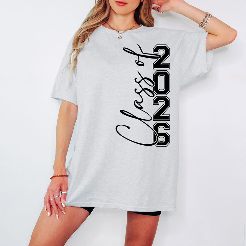 May include: Light gray t-shirt with the text "Class of 2026" in black script and block letters. The shirt is a casual style, suitable for graduation or a class reunion.