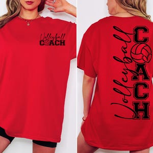 K&ouml;nnte beinhalten: Rotes T-Shirt mit kurzen &Auml;rmeln mit dem Text "Volleyball Coach" auf der Vorderseite und dem Text "Volleyball Coach" mit einer Volleyballgrafik auf der R&uuml;ckseite.