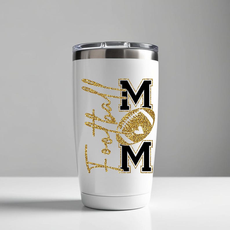 May include: White tumbler with a silver lid featuring a gold glitter football and the word "MOM" in black block letters. The words "Love Football" are in gold glitter script.