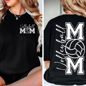 May include: Black t-shirt with white text and a volleyball graphic. The text on the front says "Volleyball Mom" and the text on the back says "Volleyball Mom" with a large "M" and a volleyball graphic.