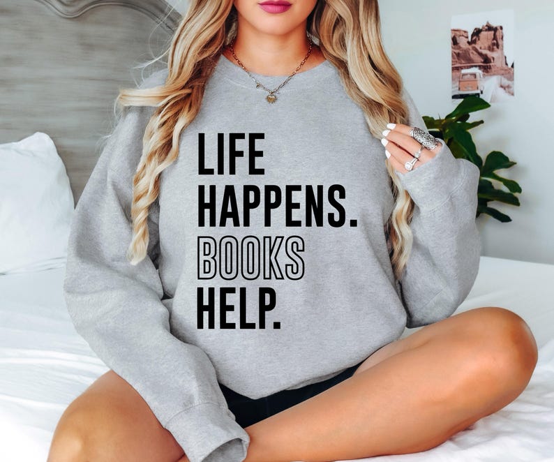 May include: Gray sweatshirt with the text "LIFE HAPPENS. BOOKS HELP." printed in black.