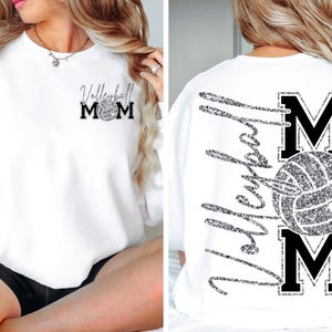 May include: White sweatshirt with "Volleyball Mom" text and a volleyball graphic in silver glitter. The design is on the front and back of the shirt. The front has a smaller design, while the back has a larger design.