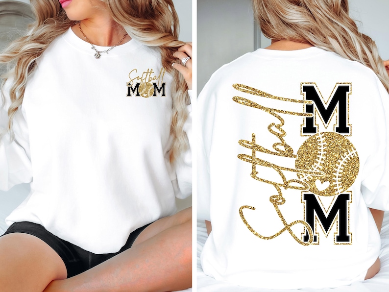 May include: White sweatshirt with gold glitter text and a softball design. The front features "Softball Mom" with a softball graphic. The back displays "Softball Mom" with a softball graphic. A comfortable, casual top for softball enthusiasts.