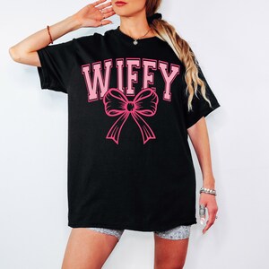 May include: Black oversized t-shirt with the text "WIFFY" in pink letters and a pink bow.