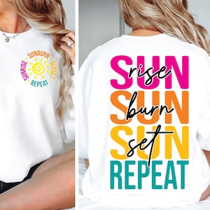 May include: White sweatshirt with the words "Sunrise, Sunburn, Sunset, Repeat" printed on the front and back. The front design features a yellow sun graphic. The back design has the words "Sun Rise, Sun Burn, Sun Set, Repeat" in pink, orange, yellow, and teal.