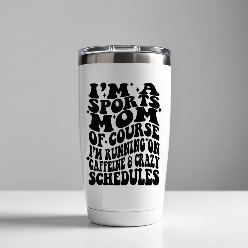 Pode incluir: Um copo t&eacute;rmico de a&ccedil;o inoxid&aacute;vel branco com um gr&aacute;fico preto que diz "Eu sou uma m&atilde;e esportiva, claro que eu corro na cafe&iacute;na e em hor&aacute;rios loucos".
