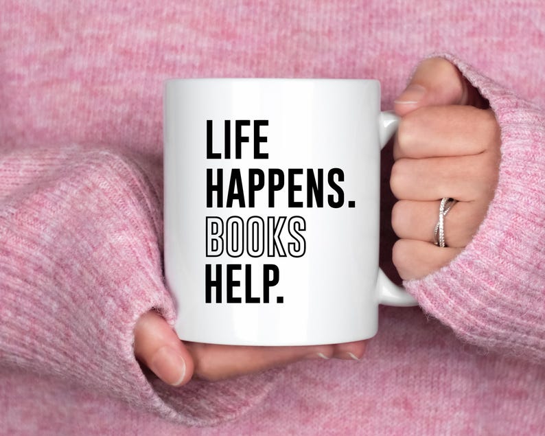 May include: White ceramic mug with black text that reads "Life Happens. Books Help."