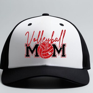 Peut inclure: Casquette de baseball noire et blanche avec l'inscription "Volleyball Mom" en paillettes rouges. Le "O" de "Mom" est remplac&eacute; par un graphique de ballon de volley-ball rouge. La casquette a une visi&egrave;re incurv&eacute;e et un dos en filet.