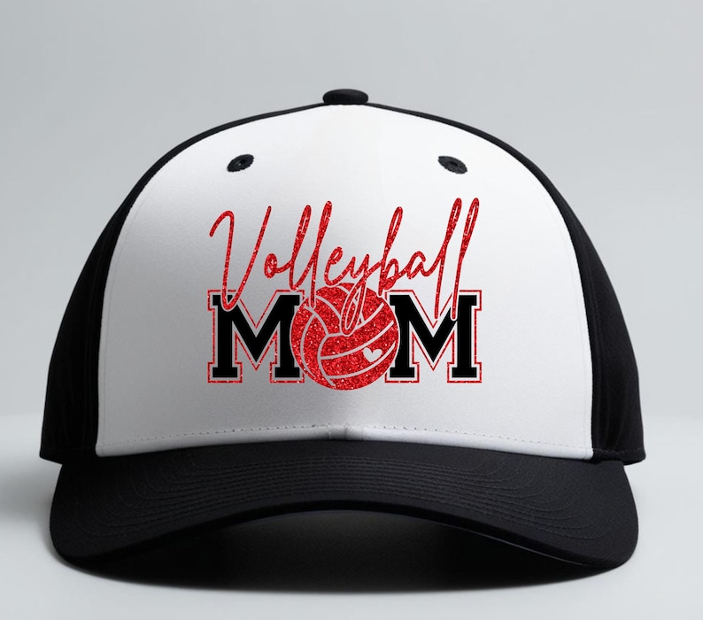 Peut inclure: Casquette de baseball noire et blanche avec l'inscription "Volleyball Mom" en paillettes rouges. Le "O" de "Mom" est remplac&eacute; par un graphique de ballon de volley-ball rouge. La casquette a une visi&egrave;re incurv&eacute;e et un dos en filet.