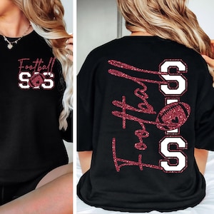 May include: Black long-sleeve shirt with the text "Football" and "SOS" in a glittery maroon font, along with a football graphic. The same design is on the back of the shirt.