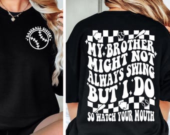 May include: Black crew neck t-shirt with white text and baseball graphics. The front of the shirt says "Baseball Sister" with a baseball graphic. The back says "My brother might not always swing but I do, so watch your mouth."