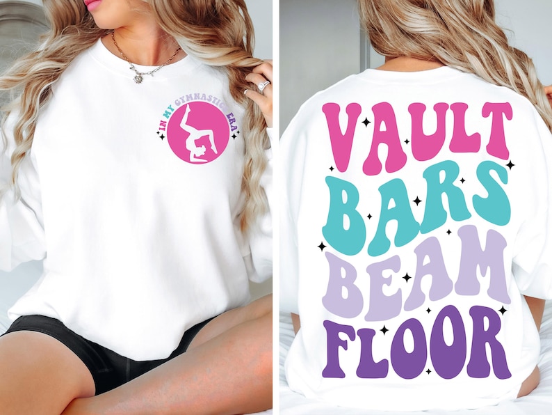 May include: White sweatshirt with a pink circle on the front that says "In My Gymnastic Era" with a silhouette of a gymnast in the circle. The back of the sweatshirt has the words "Vault Bars Beam Floor" in a retro font with pink, blue, and purple colors.