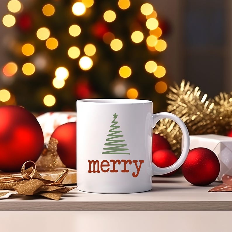 May include: White ceramic mug with a green Christmas tree design and the word "merry" in red. The mug is on a wooden surface with red ornaments and a blurred Christmas tree in the background.