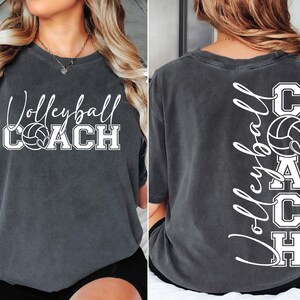 K&ouml;nnte beinhalten: Ein dunkelgraues T-Shirt mit dem Text "Volleyball Coach" und einer Volleyballgrafik auf der Vorderseite. Die R&uuml;ckseite des Shirts hat den Text "Volleyball Coach" vertikal geschrieben mit einer Volleyballgrafik.