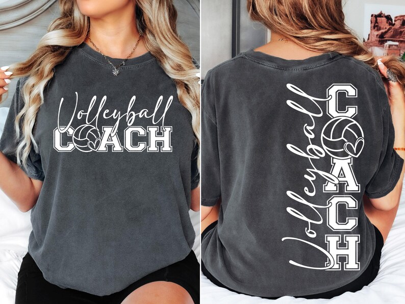 K&ouml;nnte beinhalten: Ein dunkelgraues T-Shirt mit dem Text "Volleyball Coach" und einer Volleyballgrafik auf der Vorderseite. Die R&uuml;ckseite des Shirts hat den Text "Volleyball Coach" vertikal geschrieben mit einer Volleyballgrafik.