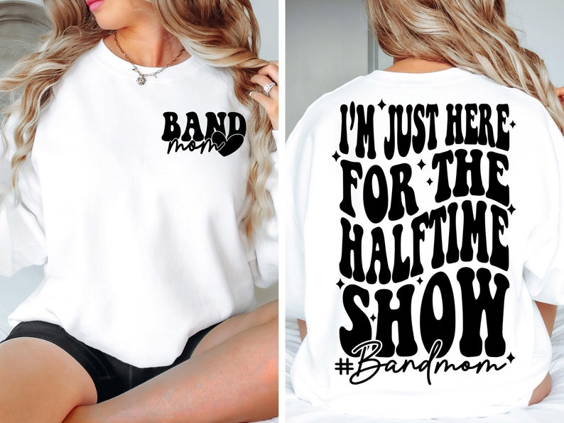 Puede incluir: Sudadera blanca con texto negro que dice "Band Mom" en la parte delantera y "I'm just here for the halftime show #Bandmom" en la parte trasera.