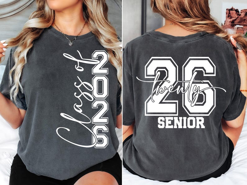 May include: Dark gray t-shirt with white text. The front reads "Class of 2026" vertically. The back displays "26 Twenty Senior" in a collegiate style. A comfortable, casual tee for graduation.