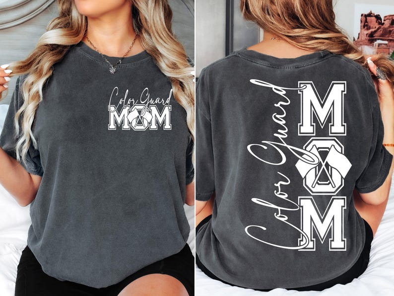 May include: A dark gray t-shirt with the text "Color Guard Mom" on the front and "Color Guard Mom" with a graphic of crossed flags on the back.
