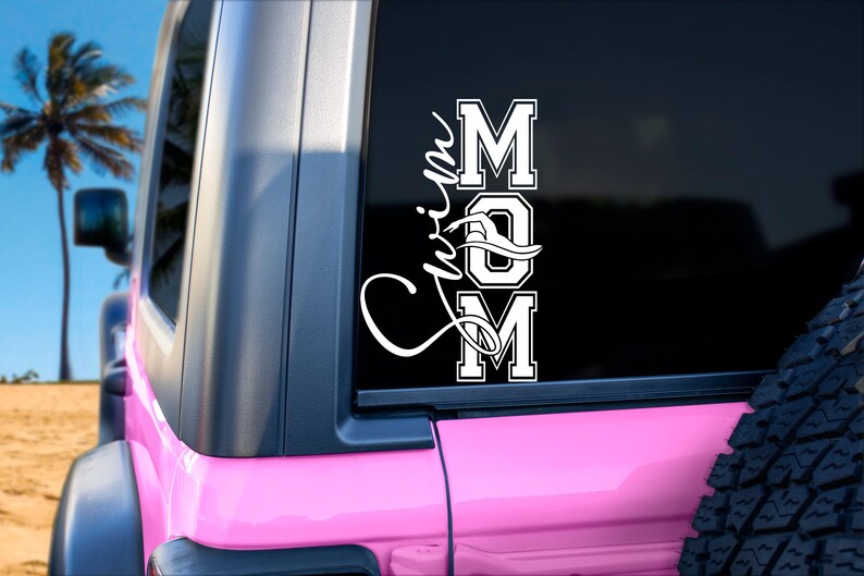 May include: A pink Jeep with a white vinyl decal on the back window that says "Swim Mom" with a stylized wave design.