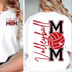Peut inclure: Sweat-shirt blanc avec l'inscription "Volleyball Mom" en lettres rouges scintillantes et en blocs noirs. Un ballon de volley-ball rouge avec un c&oelig;ur est centr&eacute; dans le motif. Le m&ecirc;me motif est au dos.