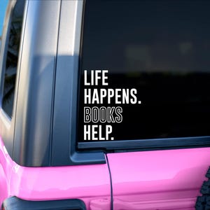 May include: A pink Jeep with a white vinyl sticker on the back window that reads "Life Happens. Books Help."