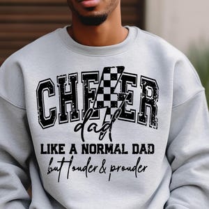 Puede incluir: Sudadera gris con un diseño de bandera a cuadros blanco y negro y el texto "Checker dad like a normal dad but louder & prouder".