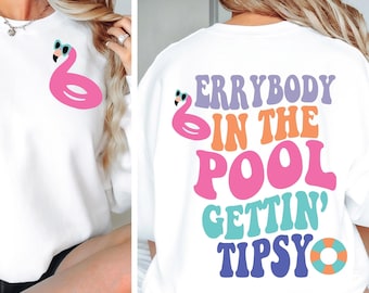 May include: White sweatshirt with a pink flamingo graphic wearing sunglasses on the front. The back of the sweatshirt has the text "Errybody in the pool gettin' tipsy" in colorful bubble letters.