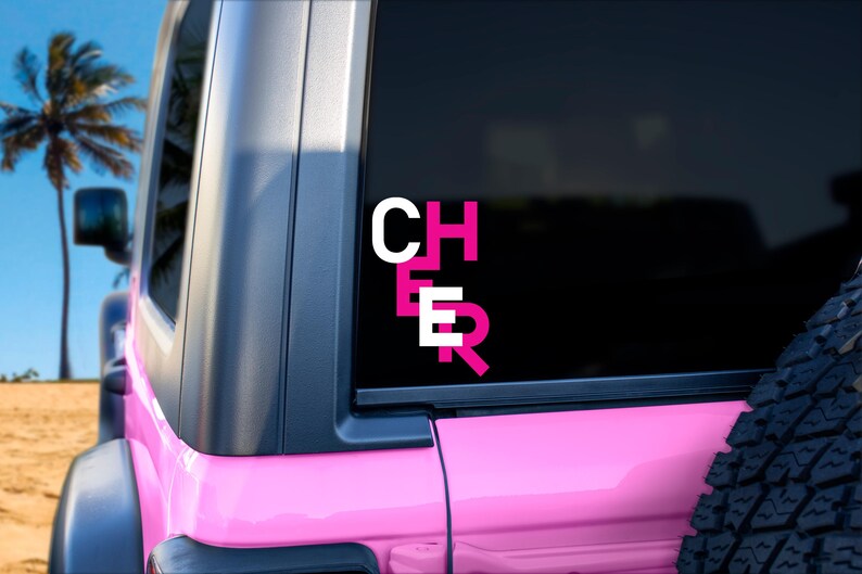 May include: Pink Jeep with a black window and a white and pink "CHEER" decal on the back window.