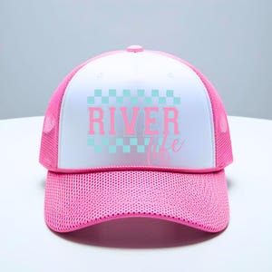 May include: A pink and white trucker hat with a checkered pattern and the text "River Life" in pink letters.