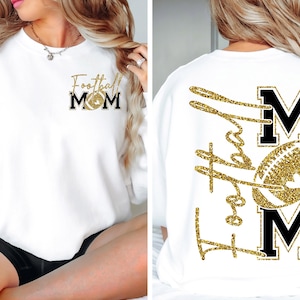 May include: White sweatshirt with gold glitter text and a football graphic. The front says "Football Mom" with a football graphic. The back has "Football Mom" in gold glitter with a football graphic between the letters M.