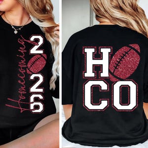 May include: Black t-shirt with "Homecoming 2022" in a vertical script and a football graphic on the front. The back of the shirt features "HC CO" with a football graphic. The text and football are in white and red glitter.