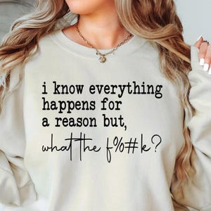 以下が含まれることがあります： 「i know everything happens for a reason but, what the f%#k?」と黒い文字で書かれたクリーム色のスウェットシャツ。スウェットシャツは長袖で、クルーネックです。