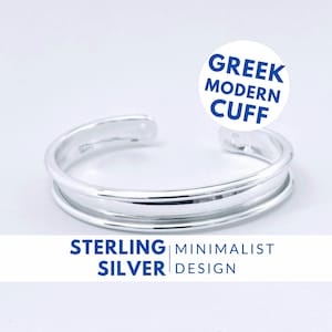 Könnte beinhalten: Sterling Silber Armreif mit minimalistischem Design. Der Armreif hat ein doppeltes Band und wird als griechischer moderner Armreif bezeichnet.