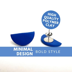 Puede incluir: Un par de pendientes de arcilla polimérica azul en forma de semicírculo. Los pendientes son de diseño minimalista y tienen un estilo audaz. El texto "HIGH QUALITY POLYMER CLAY" es visible en la imagen.