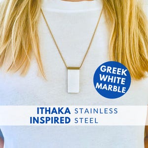 Peut inclure: Un collier en acier inoxydable doré avec un pendentif rectangulaire en marbre blanc. Le pendentif est suspendu à une chaîne délicate. Le texte "Greek White Marble" et "Ithaka Stainless Steel Inspired" sont visibles.