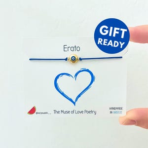 Può includere: Braccialetto in corda blu con un ciondolo dorato con un occhio turco blu. Il braccialetto è su una carta bianca con il testo "Erato - La Musa della Poesia d'Amore" e "Fatto a mano in Grecia".