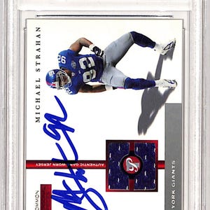 May include: A Beckett Authenticated 2005 Topps Pristine Personal Pieces Michael Strahan football card. The card features a photo of Strahan in a blue and white New York Giants uniform, with his signature in blue ink. The card is labeled "Common" and includes a small patch of game-worn jersey.