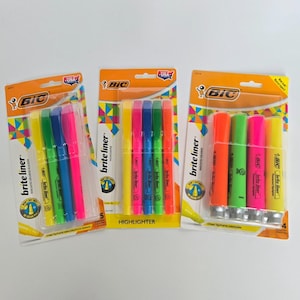 Puede incluir: Tres paquetes de resaltadores BIC Brite Liner. Cada paquete presenta una variedad de colores fluorescentes, incluyendo rosa, verde, amarillo, azul y naranja. El embalaje es naranja y blanco con el logotipo de BIC e información del producto.