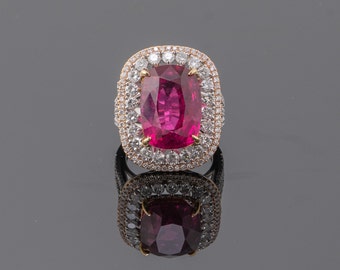 May include: A ring with a large, pink gemstone surrounded by a double halo of smaller, white gemstones. The ring is set in gold.