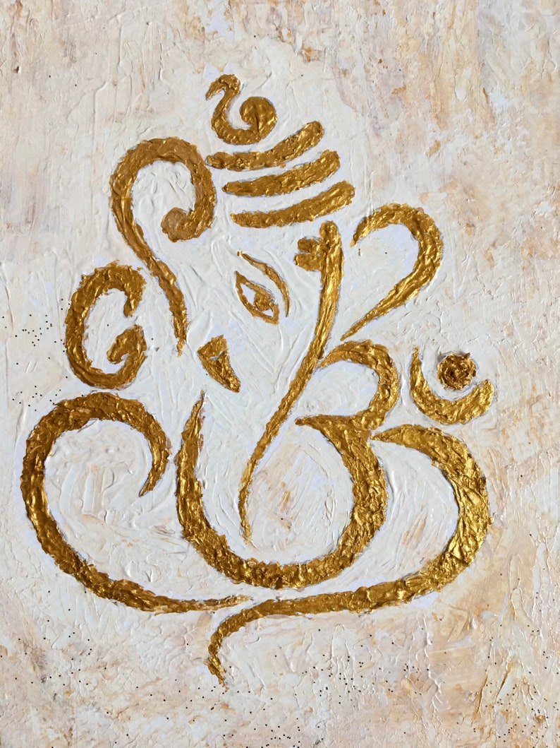 Op de afbeelding: Een gouden Ganesha-schilderij op een gestructureerde witte achtergrond. Het schilderij is een gestileerde afbeelding van de hindoe-god Ganesha, bekend om zijn olifantenkop en slurf.