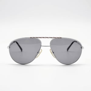 May include: Silver aviator sunglasses with a twisted metal bridge and dark gray lenses.
