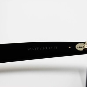May include: Black Wayfarer II sunglasses with a silver hinge detail.