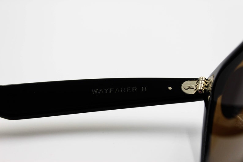 May include: Black Wayfarer II sunglasses with a silver hinge detail.