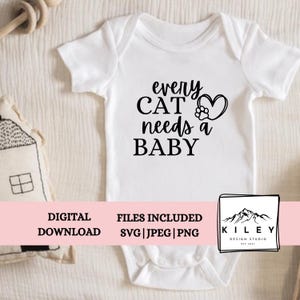 Op de afbeelding: Witte baby romper met zwarte tekst die "every CAT needs a BABY" luidt, met een pootprint en een hartvormig motief.