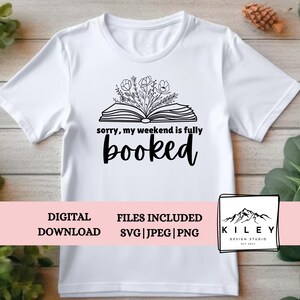 May include: A white t-shirt with a black design of an open book with flowers coming out of it. The text "sorry, my weekend is fully booked" is below the book.