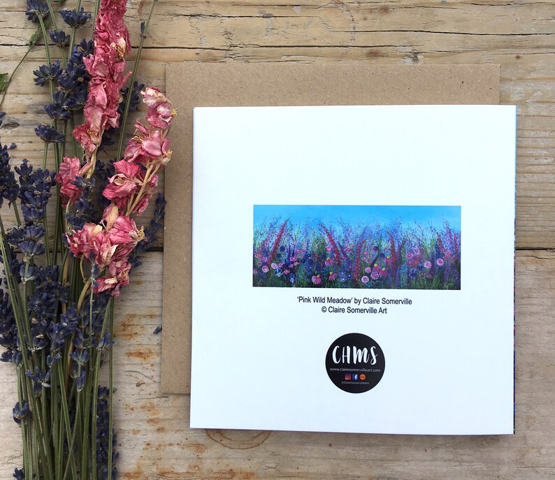 May include: A white card with a colorful painting of a field of wildflowers. The painting is titled "Pink Wild Meadow" by Claire Somerville. The card also includes the artist's website and social media handles.