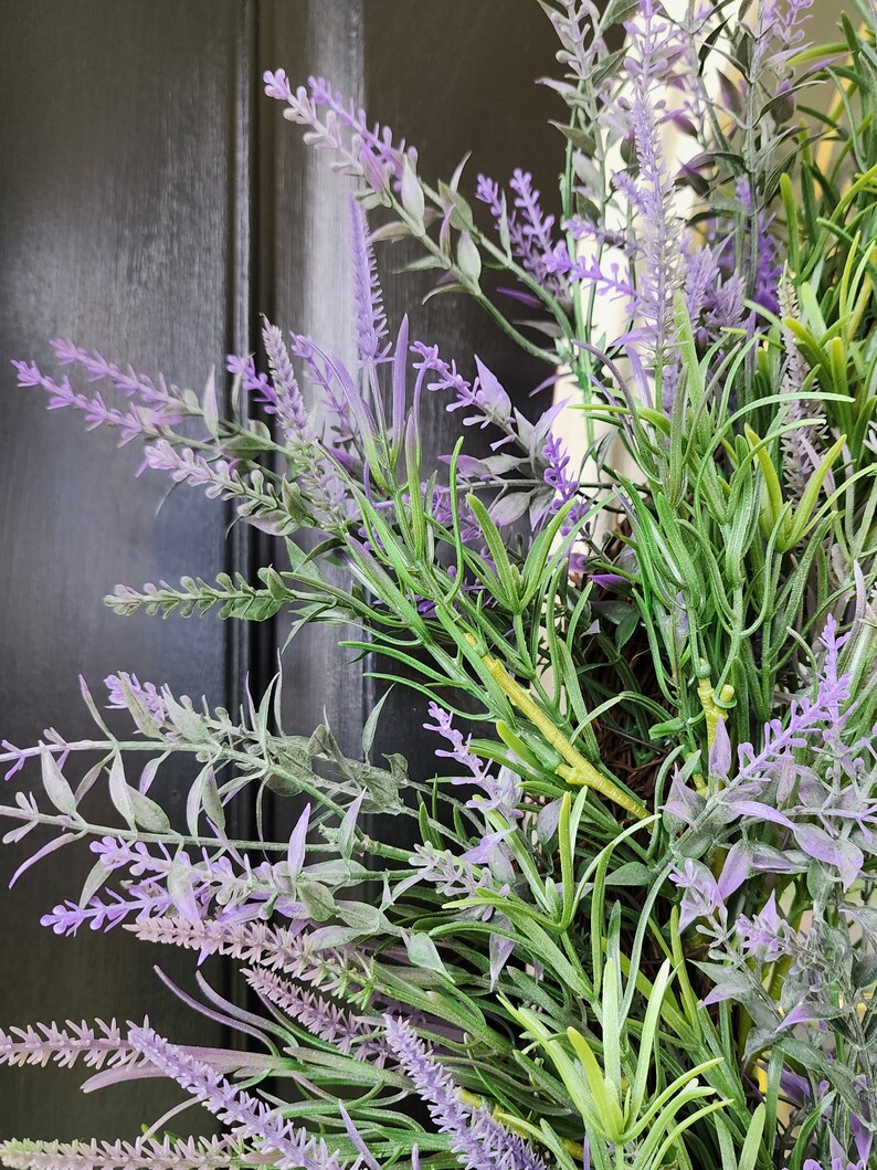 May include: A close-up of a lavender wreath with purple flowers and green leaves.